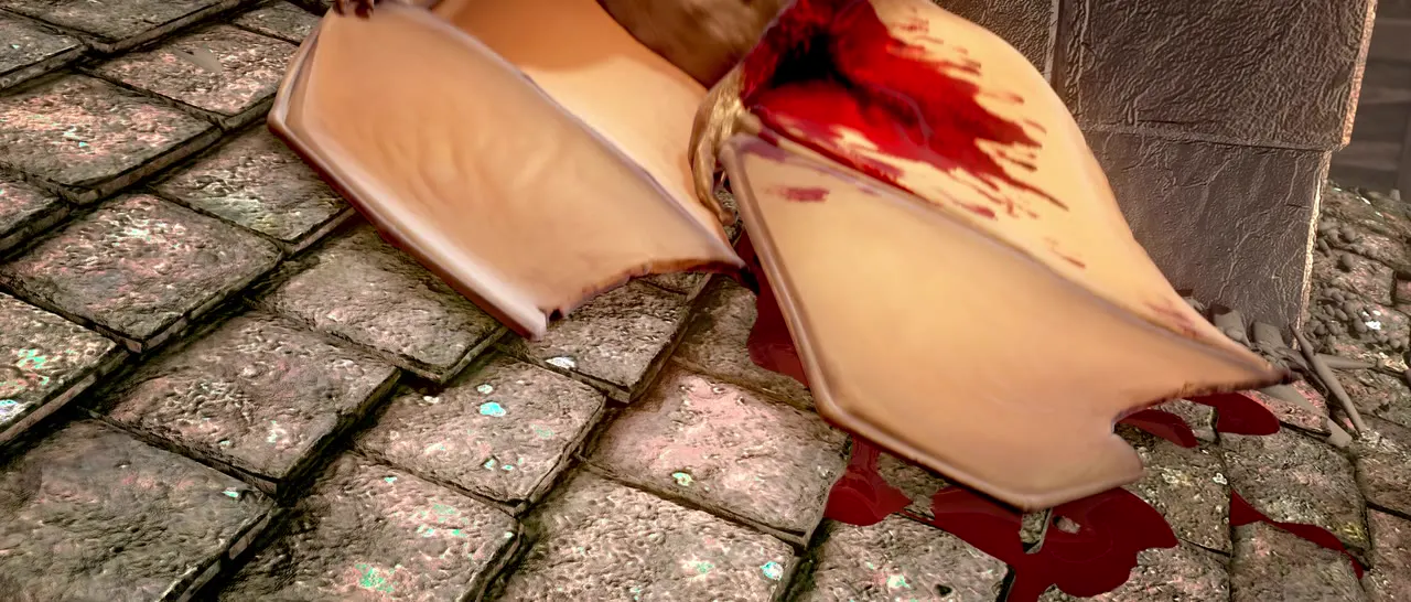 A baby dragon’s torn, bloody wing on cobblestones